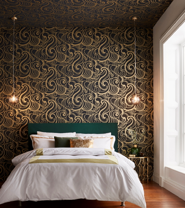 Graham & Brown behang, design Barbara Hulanicki – behang Hula Swirl Gold Noir. (Foto Graham & Brown wallpaper  op DroomHome.nl)