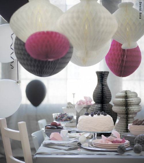 IKEA Nieuws: Feestelijke Gedekte Tafel met Nieuwe Ikea Producten als Servies, Bestek, Pompoms en Honingraatbollen Tafeldecoratie, Kandelaar en Tafelkleed. (Foto Ikea  op DroomHome.nl)