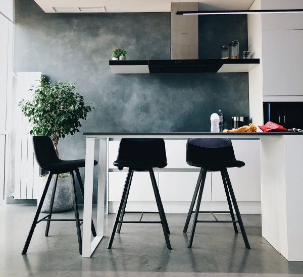 Eetkamer inrichten: Zwarte barstoelen aan de keukenbar (Foto: Vitaliy Zamedyanskiy, Unsplash  op DroomHome.nl)