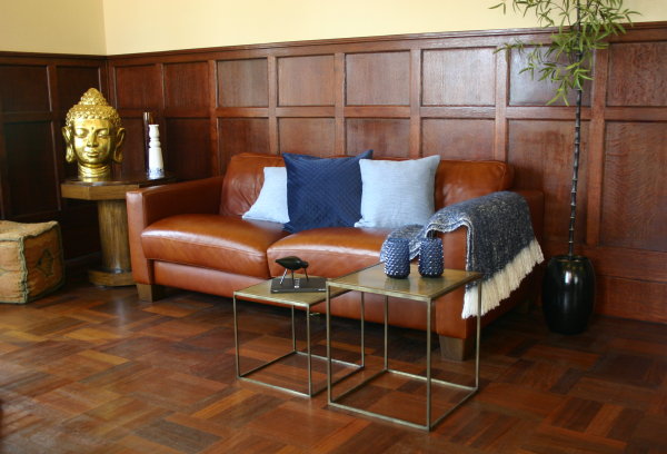 Stoere en Stijlvolle HEMA Woonaccessoires in Blauw – HEMA Kussenhoezen, Plaid op Cognac Kleurige Bank en Vazen op Koperen Bijzettafels. (Foto door DroomHome.nl)